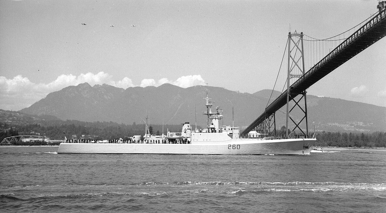 취역 당시의 HMCS 컬럼비아(함번 260)가 밴쿠버 라이온스 게이트 다리 아래를 통과하는 흑백 사진